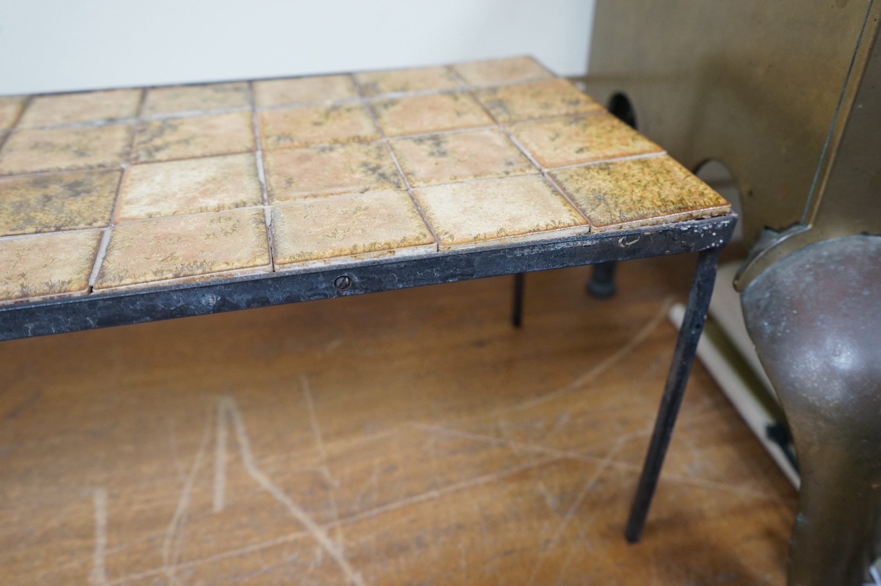 Manner of Roger Capron (French), an Iron and ceramic tile top table, 76cm wide. Condition - fair
